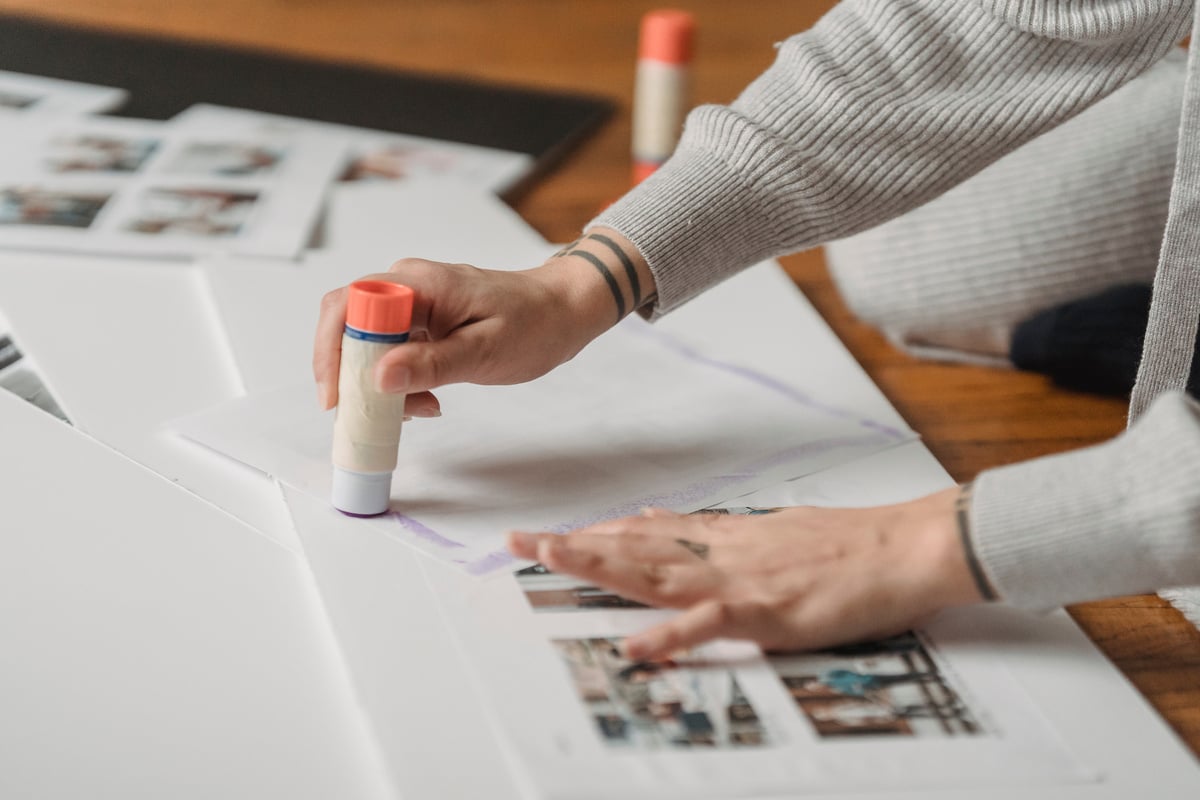 Crop unrecognizable person applying glue on papers